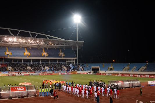 un-groupe-de-personnes-debout-sur-un-terrain-de-football-36nE5AQ0WU4