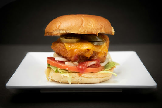 un-cheeseburger-sur-une-assiette-avec-de-la-laitue-et-des-tomates-x4YT7VT0ECE