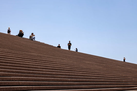 un-groupe-de-personnes-debout-sur-les-gradins-bruns-dun-stade-jn4aKaAC9g0