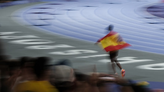 un-homme-tenant-un-drapeau-espagnol-au-sommet-dune-piste-de-course-3uuWDAzzdOE