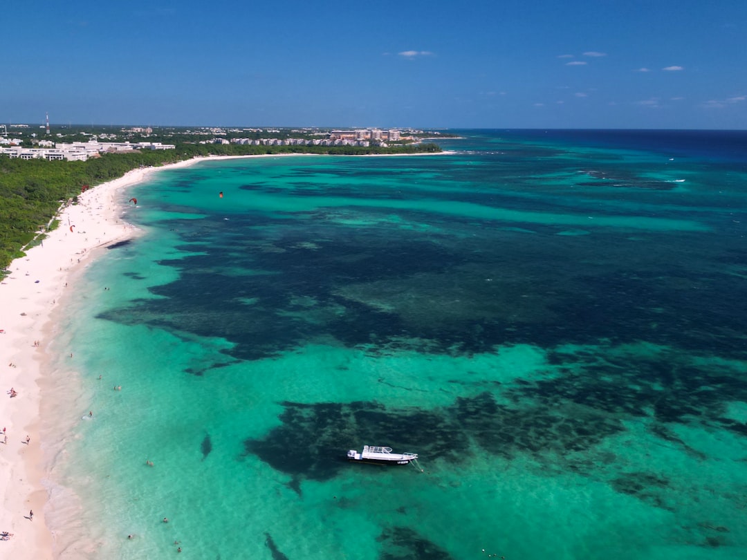 une-vue-aerienne-dune-plage-avec-un-bateau-dans-leau-I6CtuCyQzI8