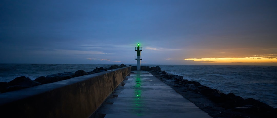 une-longue-jetee-avec-une-lumiere-verte-a-lextremite-de-celle-ci-9rCGJEuv1k0