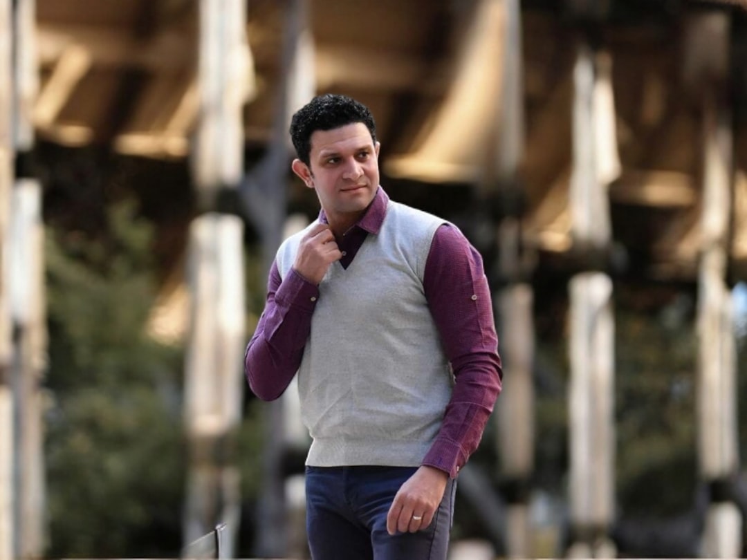 un-homme-debout-devant-un-grand-immeuble-9jzmkl6kNJw