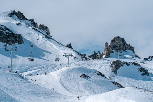 un-groupe-de-personnes-descendant-des-skis-sur-une-pente-enneigee-M49npbiWgAc