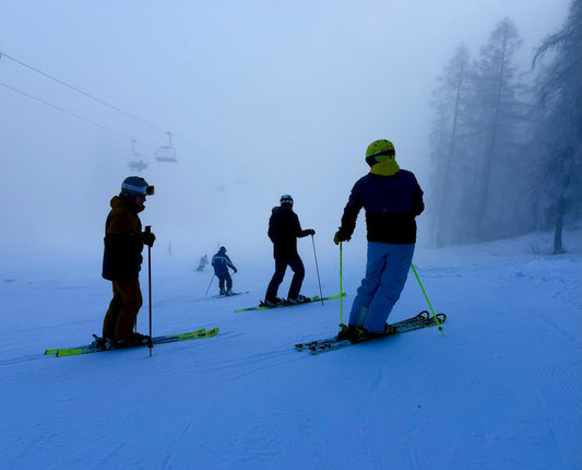 un-groupe-de-personnes-descendant-des-skis-sur-une-pente-enneigee-lCuqWY0iUF8
